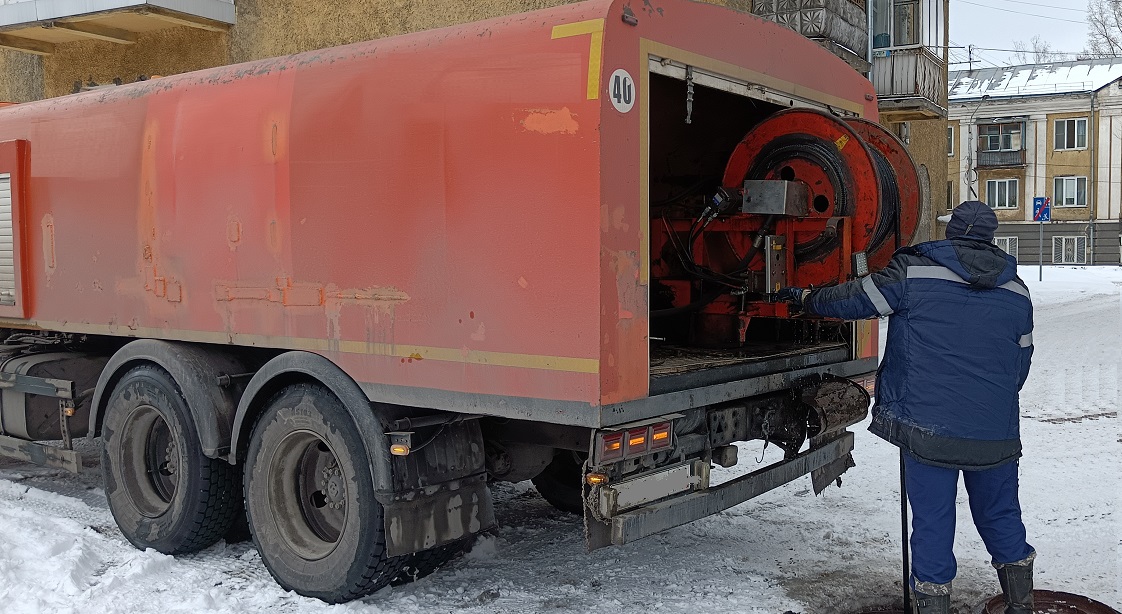 Каналопромывочная машина и работник прочищают засор в канализационной системе в Чувашии